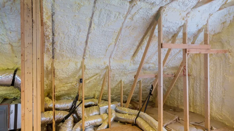 Open-cell foam sprayed along an attic roof deck between rafters