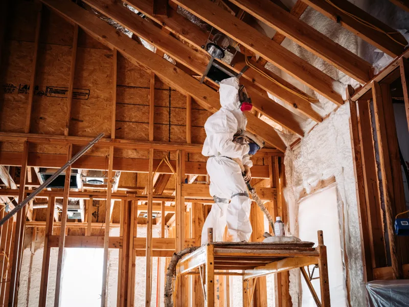 Applicator working from staging to reach a high vaulted ceiling